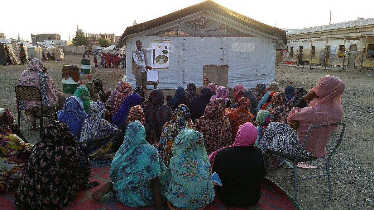 a man is presenting a poster to villagers