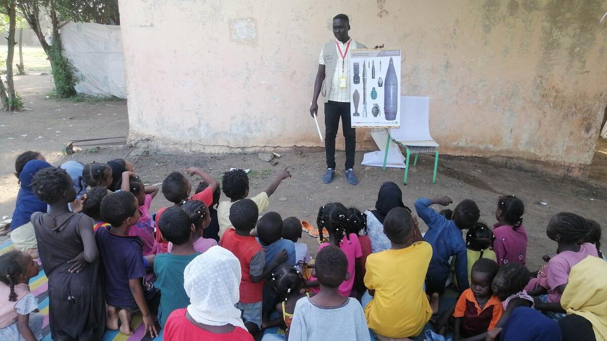 a man is presenting a poster to a group of children