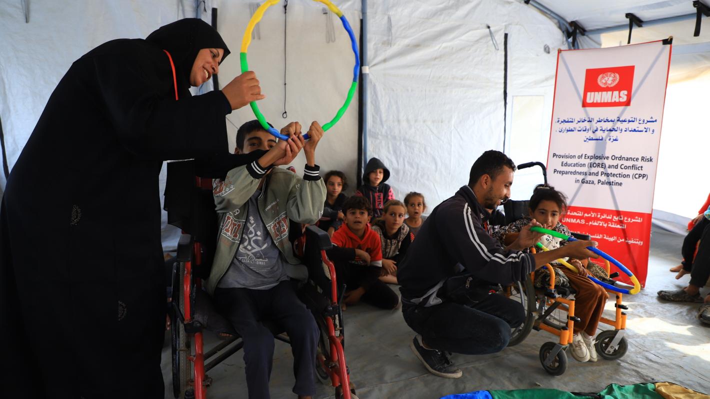 children with disabilities participate in a risk education session where facilitators teach about explosive threats using colourful toys.