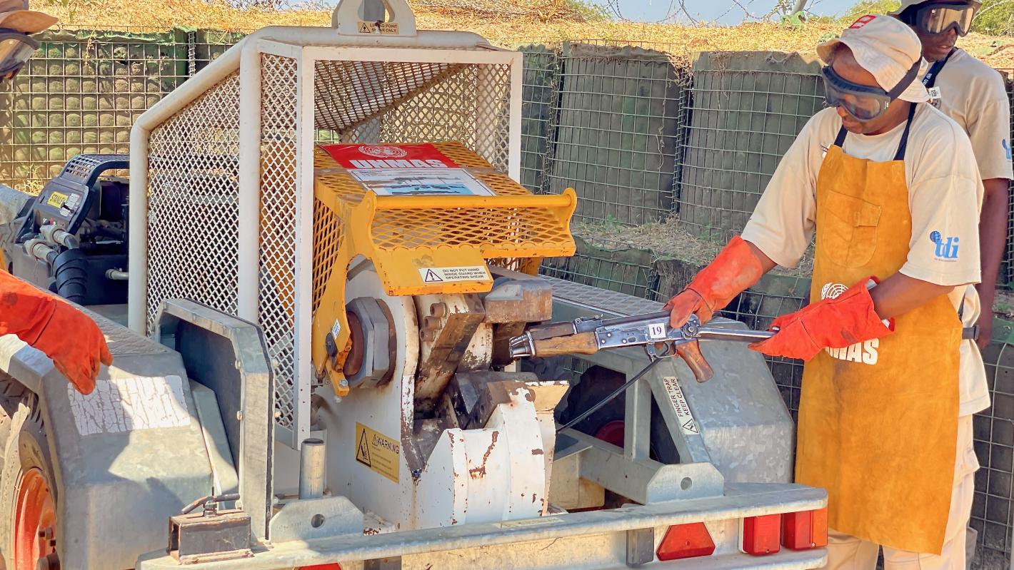 a man is destucting a weapon with a machine