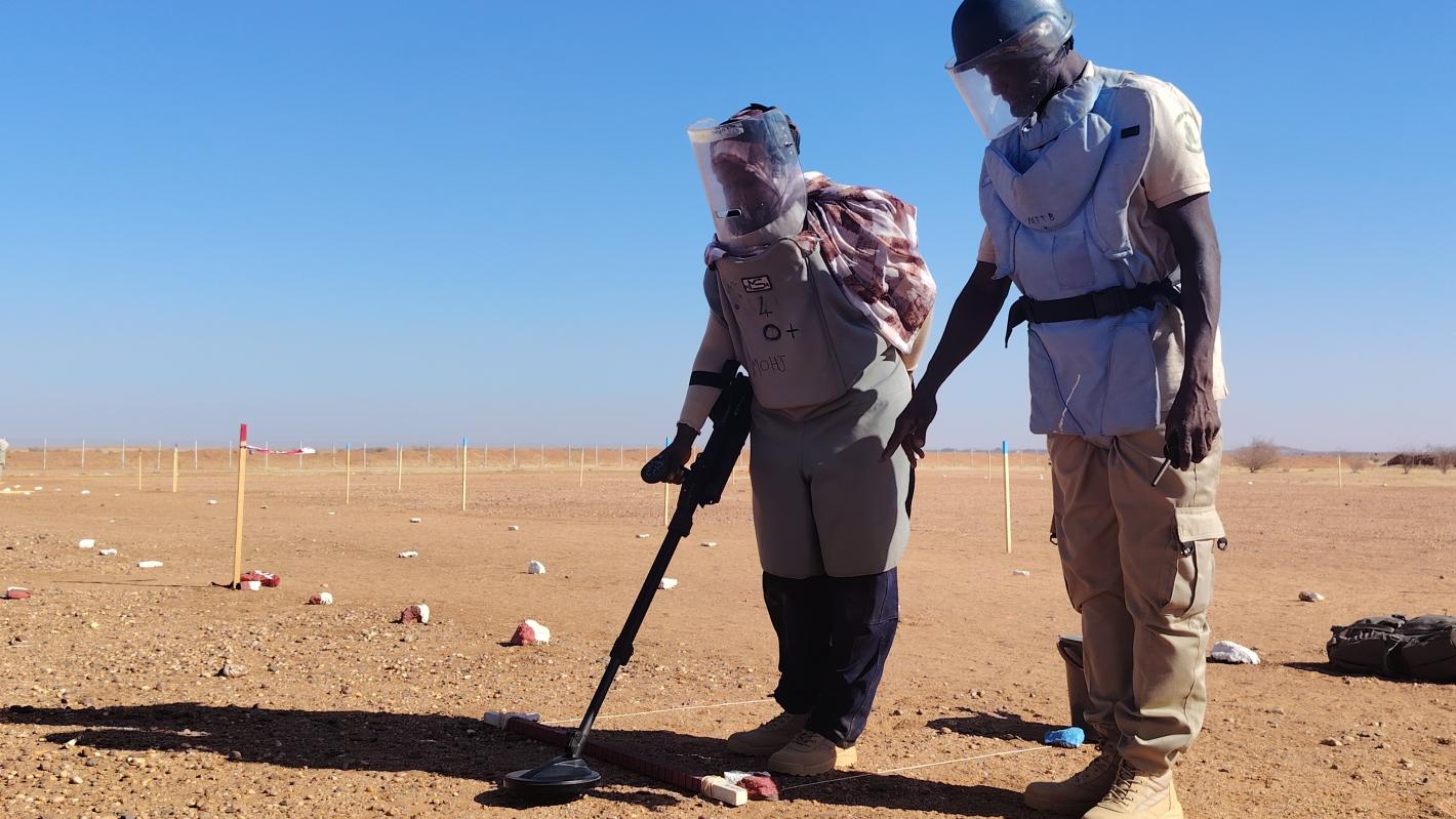 two deminers are working on a field