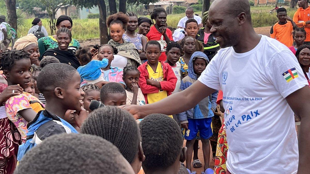 A peacekeeper speaks with a group of children