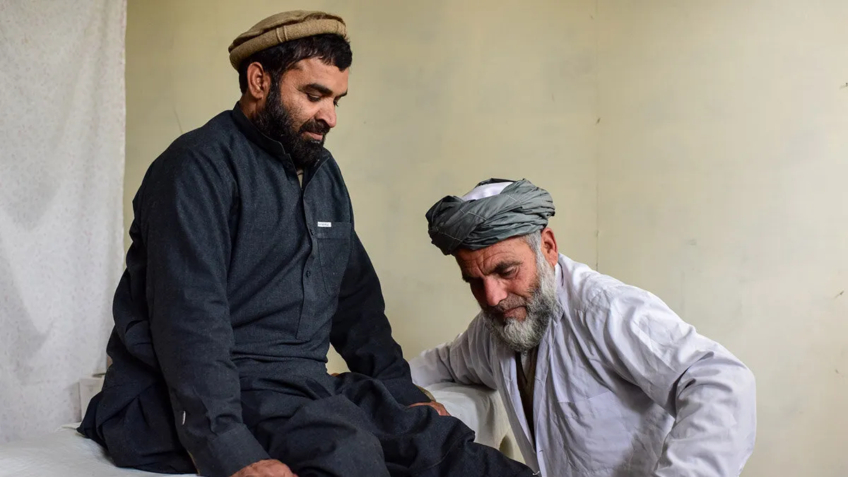 a doctor is conducting physical therapy to a mine victim