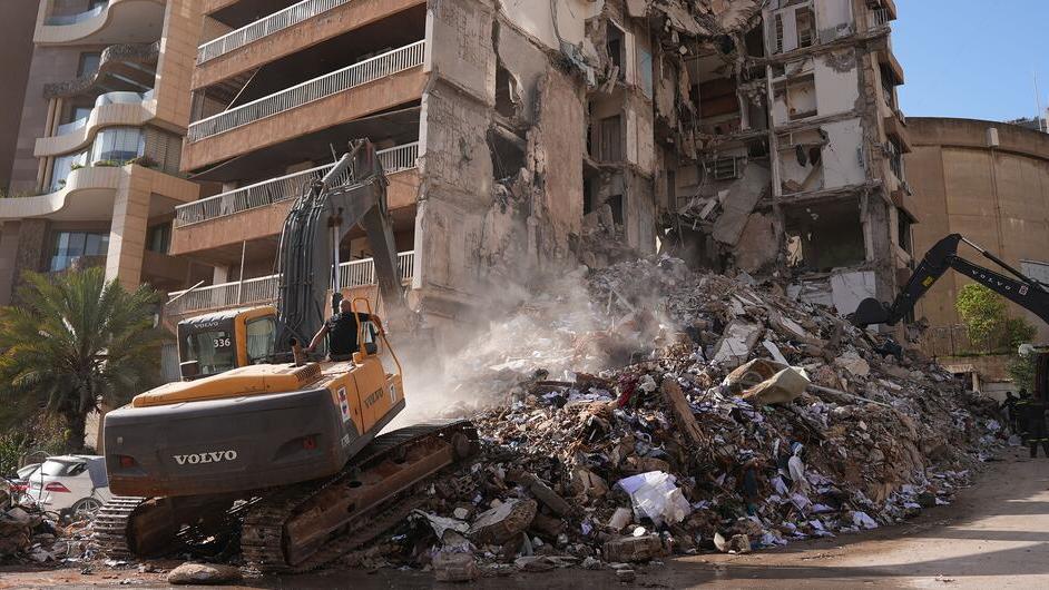 Heavy machinery clears rubble from a building destroyed by airstrikes in Beirut, Lebanon.