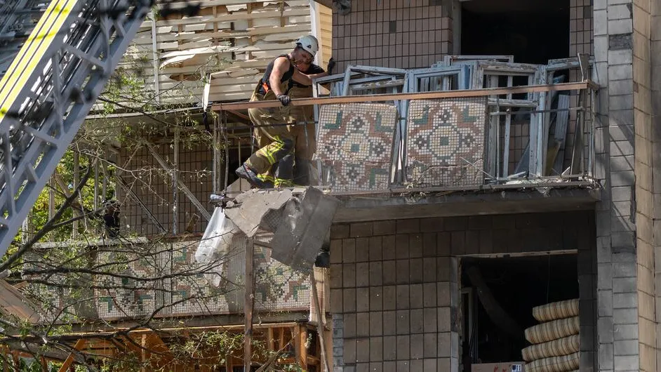 A firefighter works on the balcony of a wrecked building in Kyiv, Ukraine.