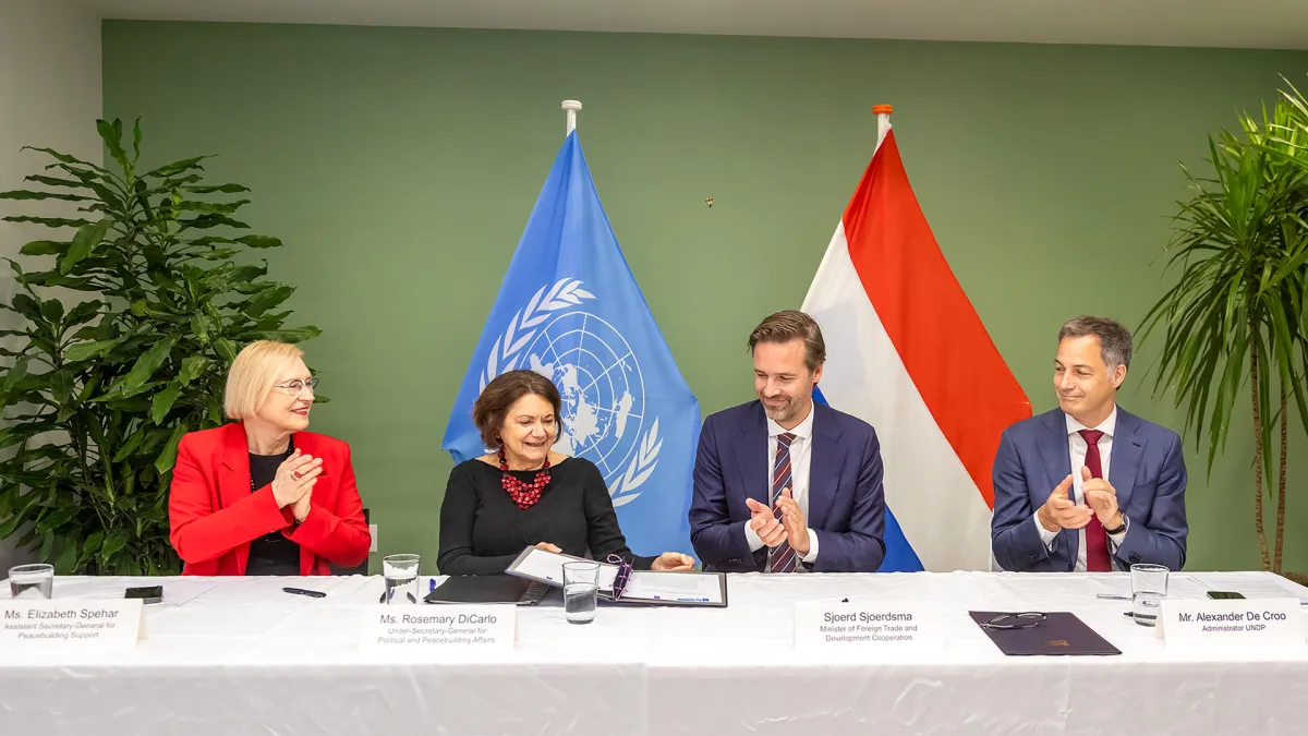 Participants applaud following the signing of a multi-year agreement through which the Netherlands pledged support to United Nations work on peace and security.