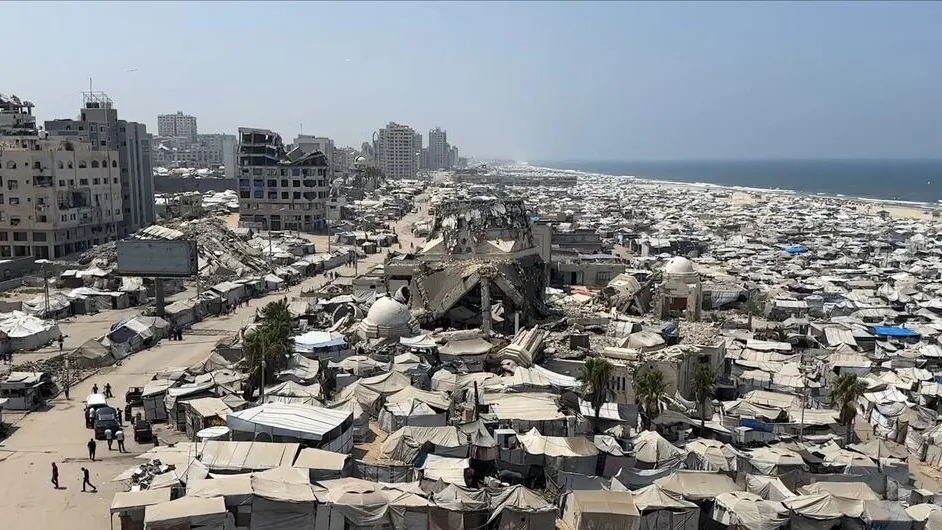 Massive tent settlement of displaced residents extends along the damaged Gaza coastline.