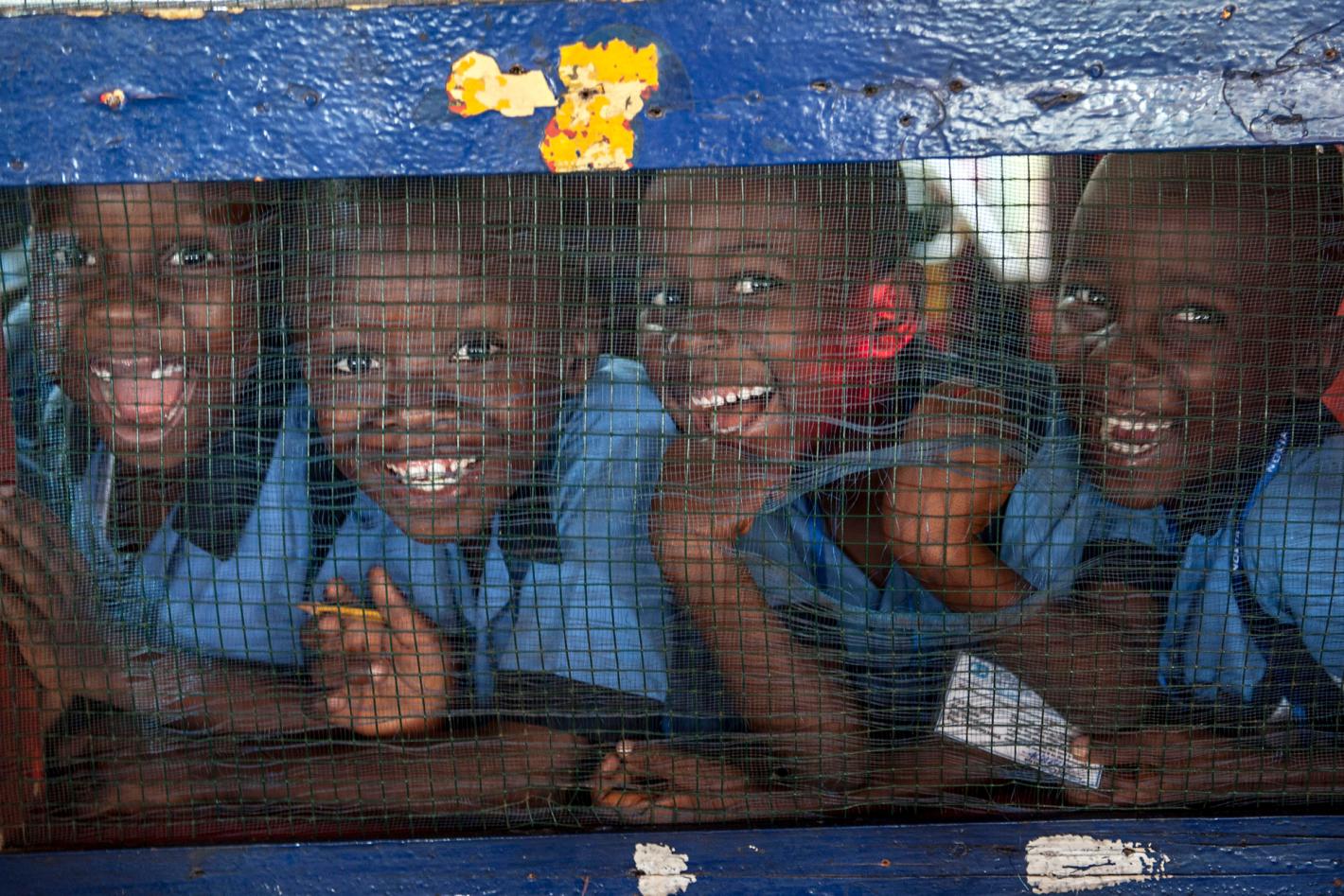 Four children in a row smiling