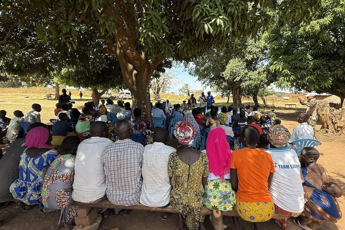 Residents of seven villages in Morobo County made the most of an opportunity to express concerns and ask questions during an outreach event with UNMISS and local leaders. Photos: Elizabeth Mpimbaza/UNMISS A group of people in brightly coloured clothing seated on wooden benches under a large tress are facing a person giving a presentation.