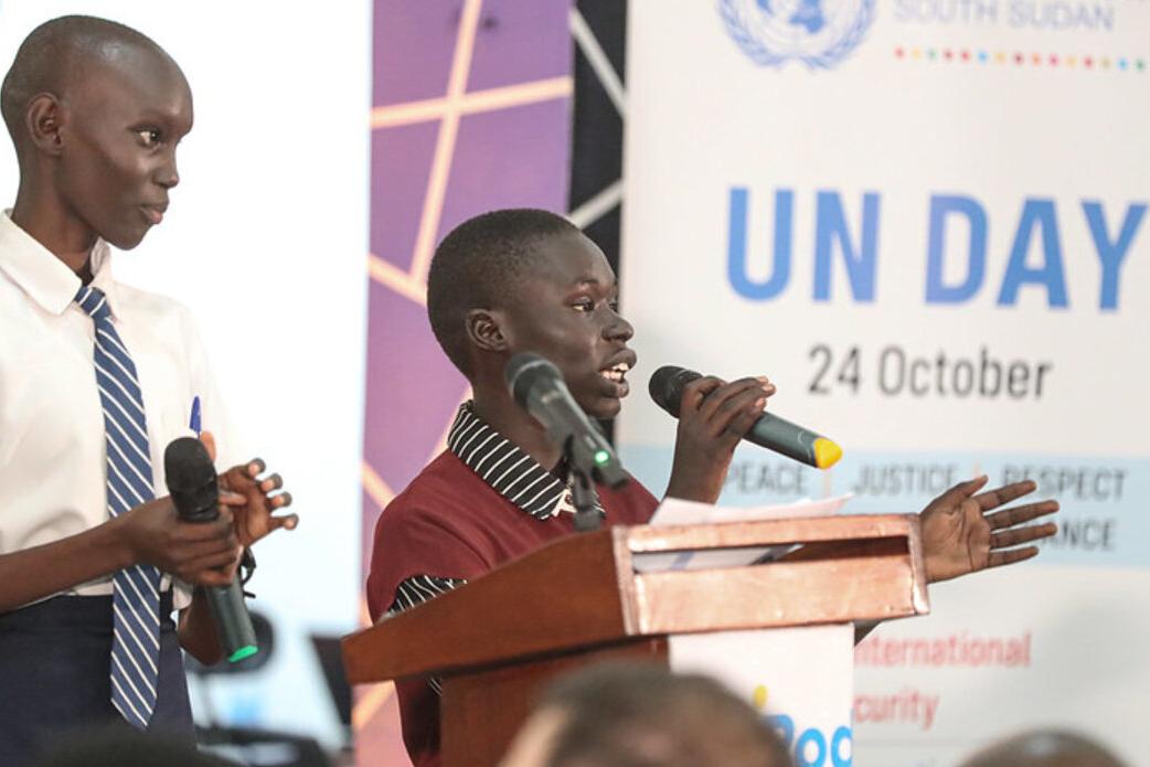On the 80th anniversary of the United Nations, a vibrant event was held to mark the Organization’s contribution to peace and development in South Sudan, including a storytelling photo exhibition of the UN contributions in the country. Two individuals speaking at a podium with microphones during a UN Day event, with a banner showing ‘UN Day 24 October’ in the background.