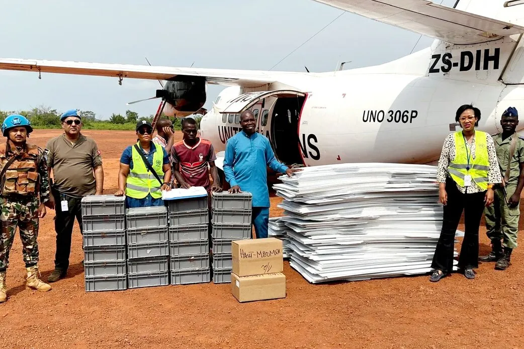 Des Casques bleus de la MINUSCA se tiennent au sol à côté d'un avion de l'ONU