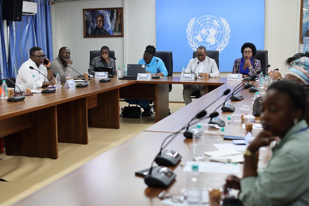Meeting participants sit around a table.