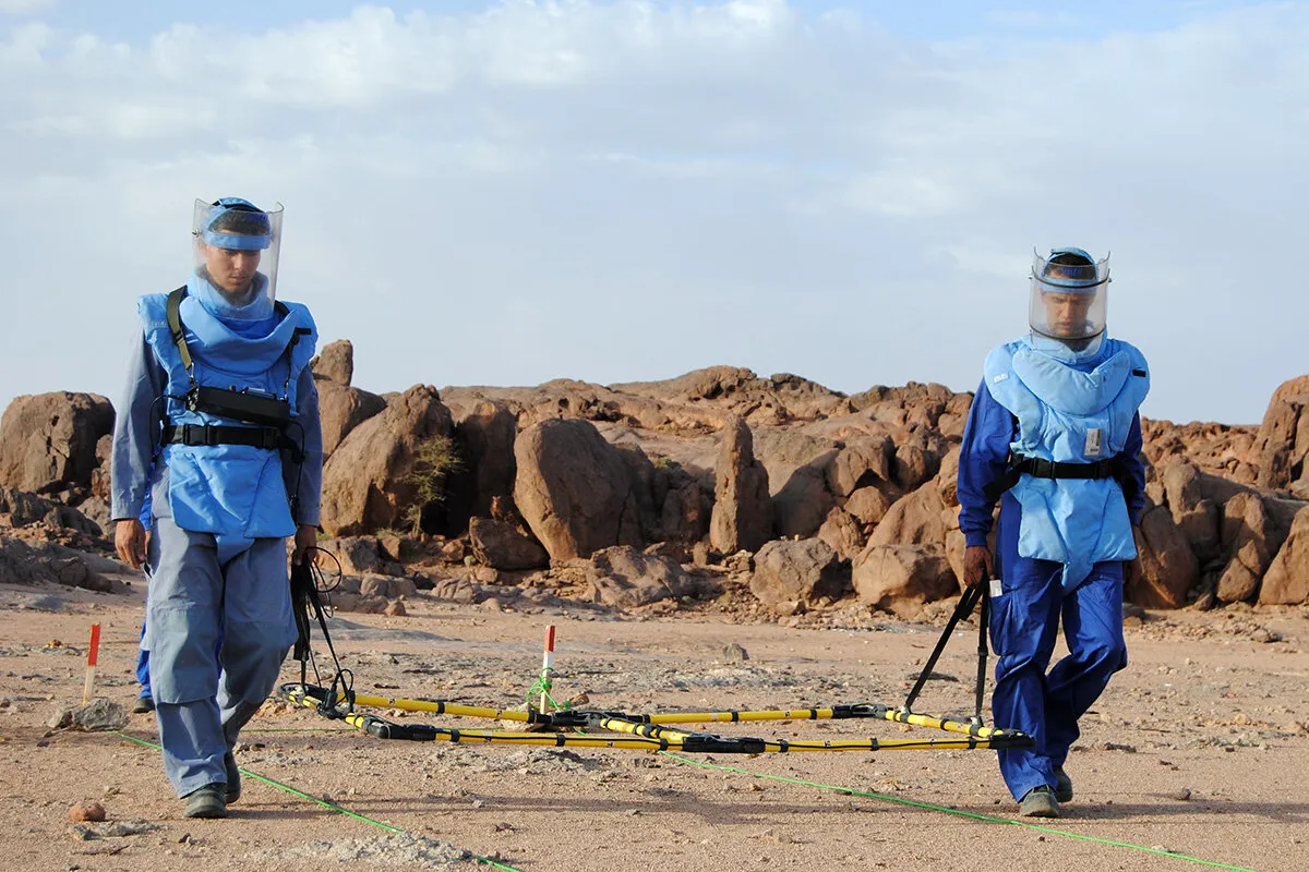 two demining operators areworking on the field