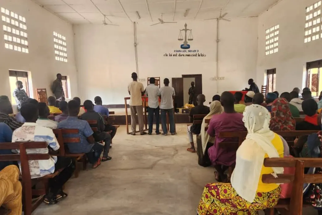 Un public est assis dans une salle d’audience.