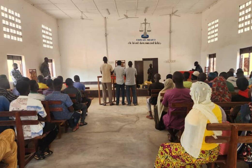 Un public est assis dans une salle d’audience.
