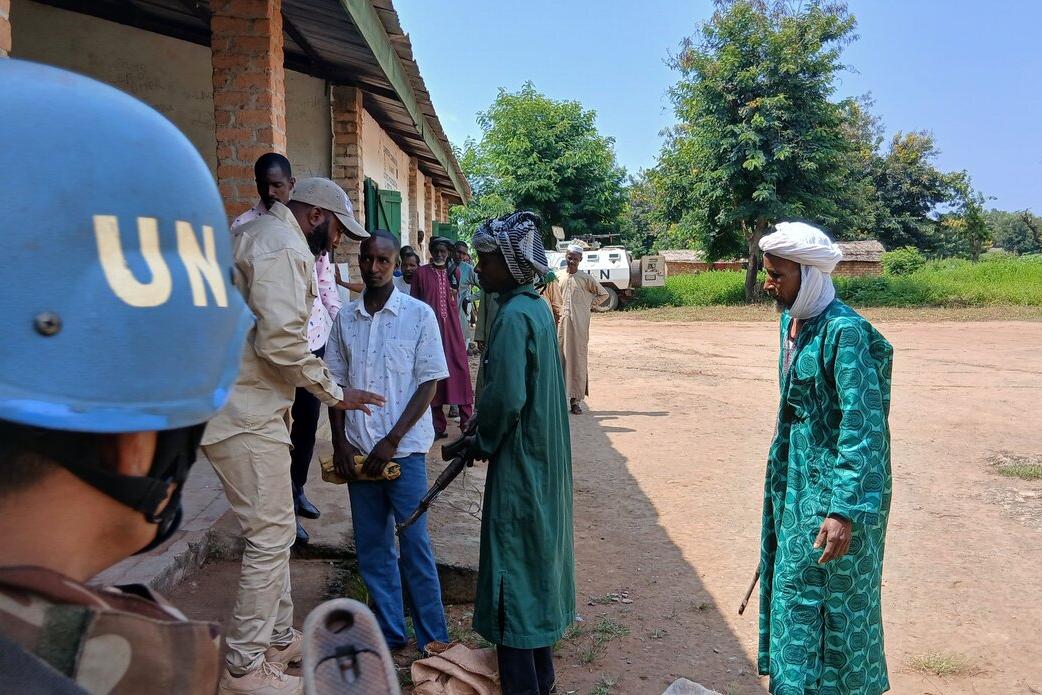 Un casque bleu et un représentant parlent avec d’anciens combattants.