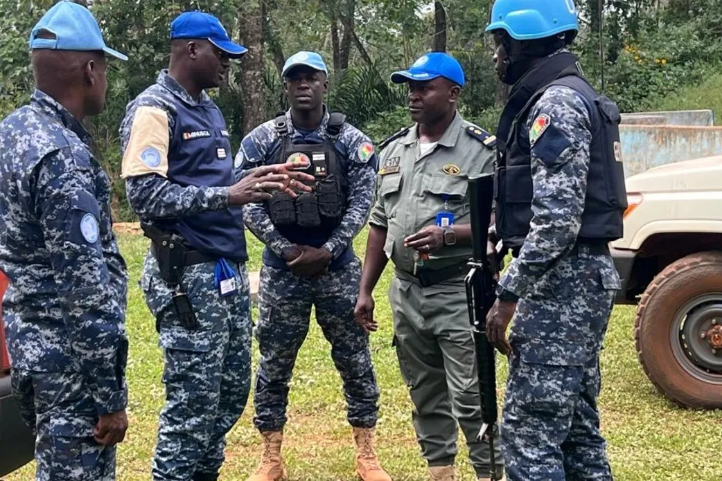 Un groupe de casques bleus discute à l'extérieur.