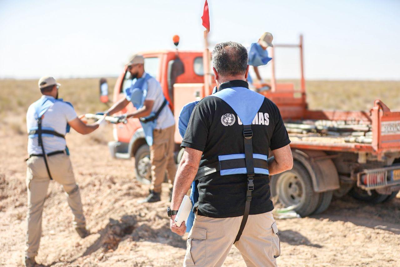 the back of man wearing black T-shirt walking towards a truck
