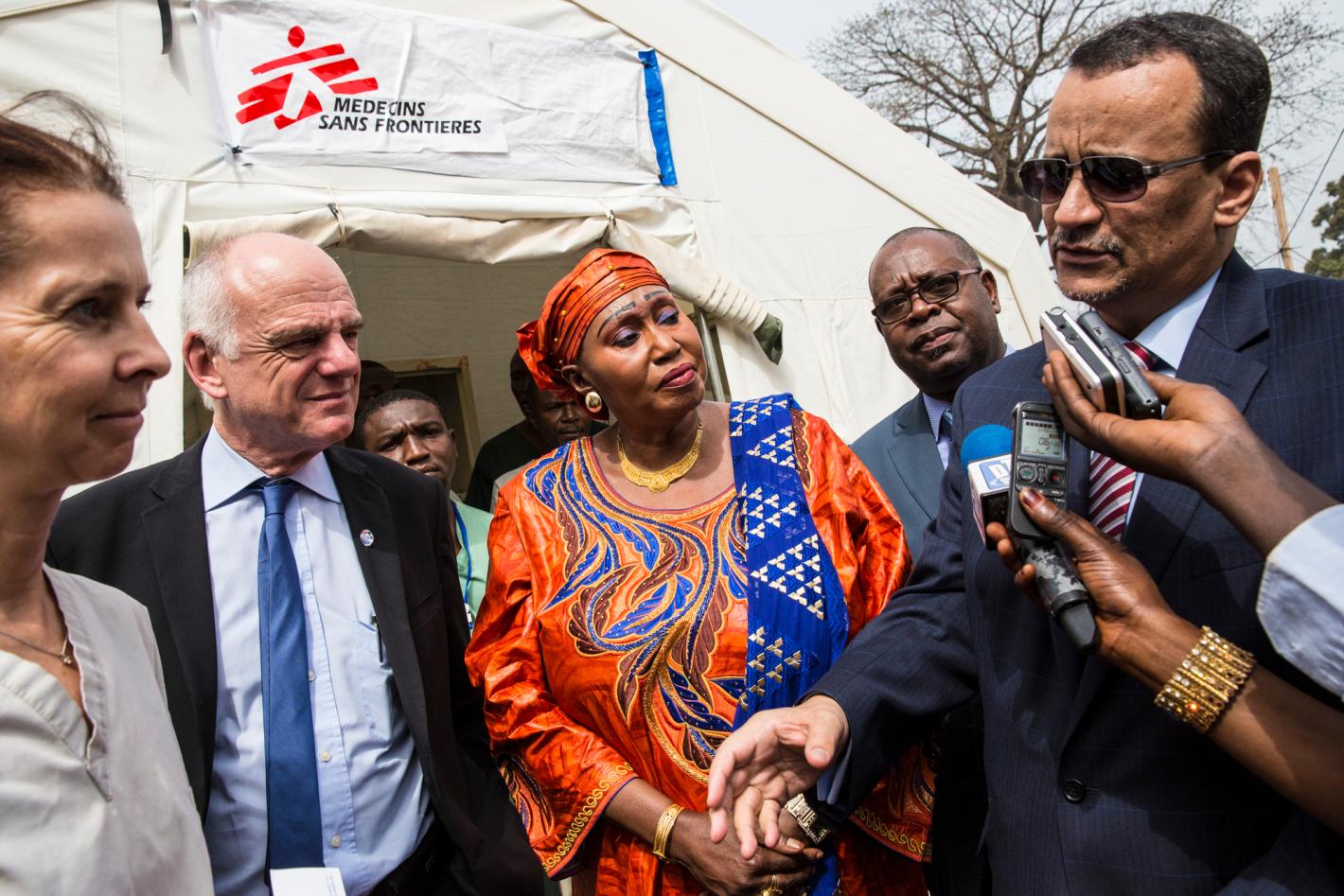 Ismail Ould Cheikh Ahmed (right), Special Representative of the Secretary-General and Head of the UN Mission for Ebola Emergency Response (UNMEER) standing to the right with microphones and recorders near his mouth. Surrounding him are other officials in business attire.