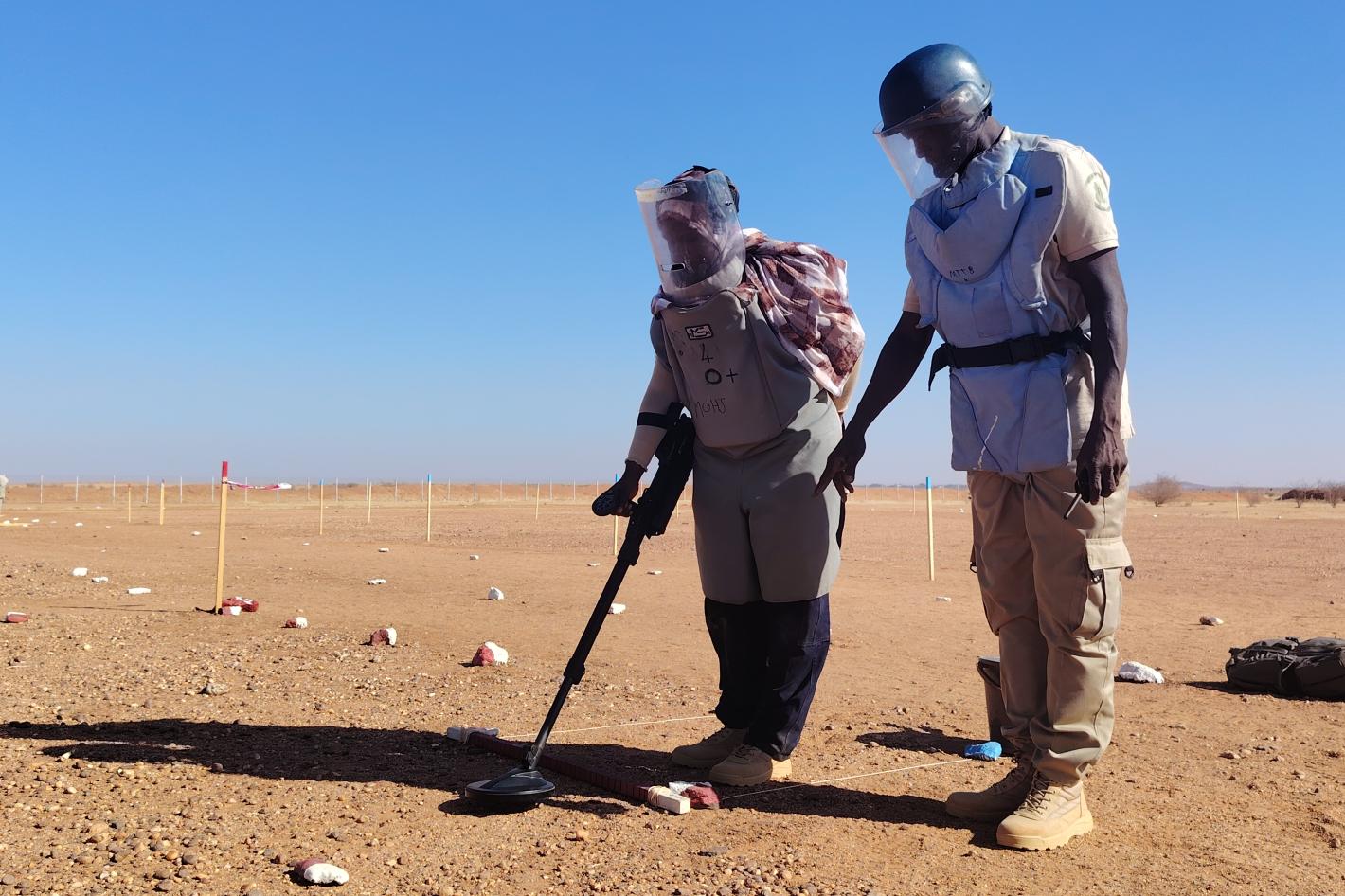 two deminers are working on a field