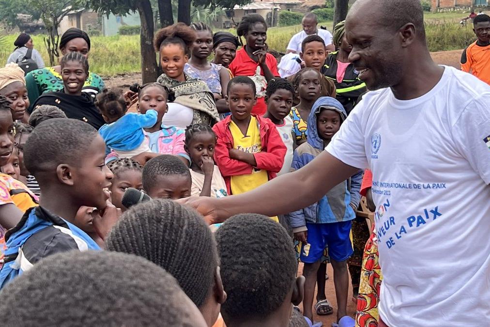A peacekeeper speaks with a group of children
