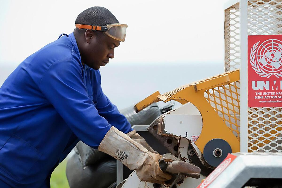 a man is destroying a weapon with a machine