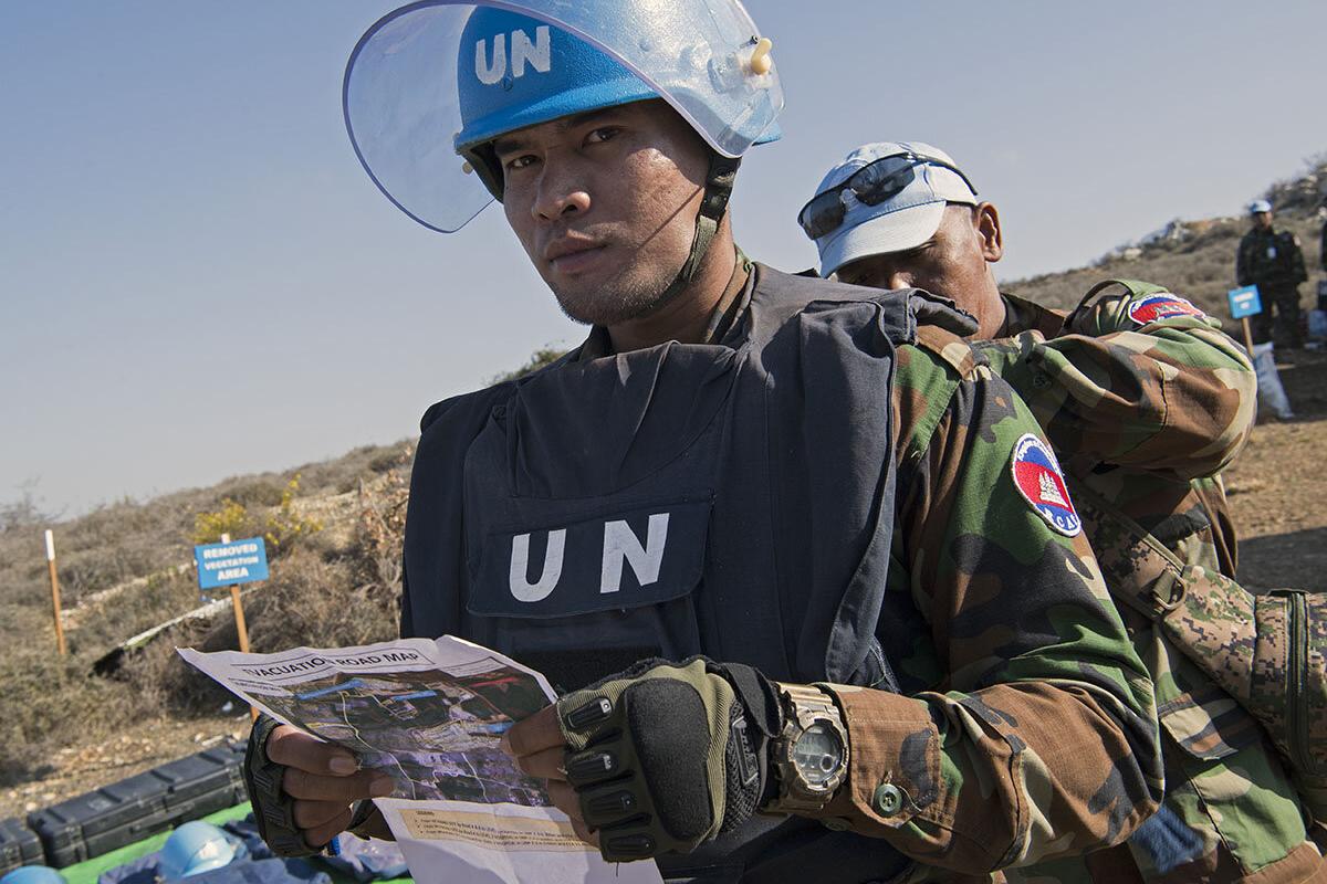 A Cambodian team leader revises safety requirements before entering the hazardous area on a minefield near Rmeish, south Lebanon. 