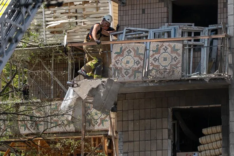 A firefighter works on the balcony of a wrecked building in Kyiv, Ukraine.
