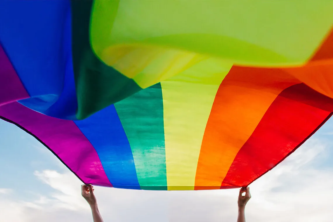 A pride flag flutters in the wind