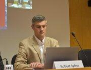 a man sitting in front of a laptop