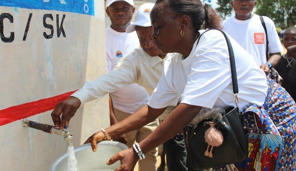 A woman collects water from the newly installed tap in Shabunda, DRC. Photo credit: UN Photo/DDDR